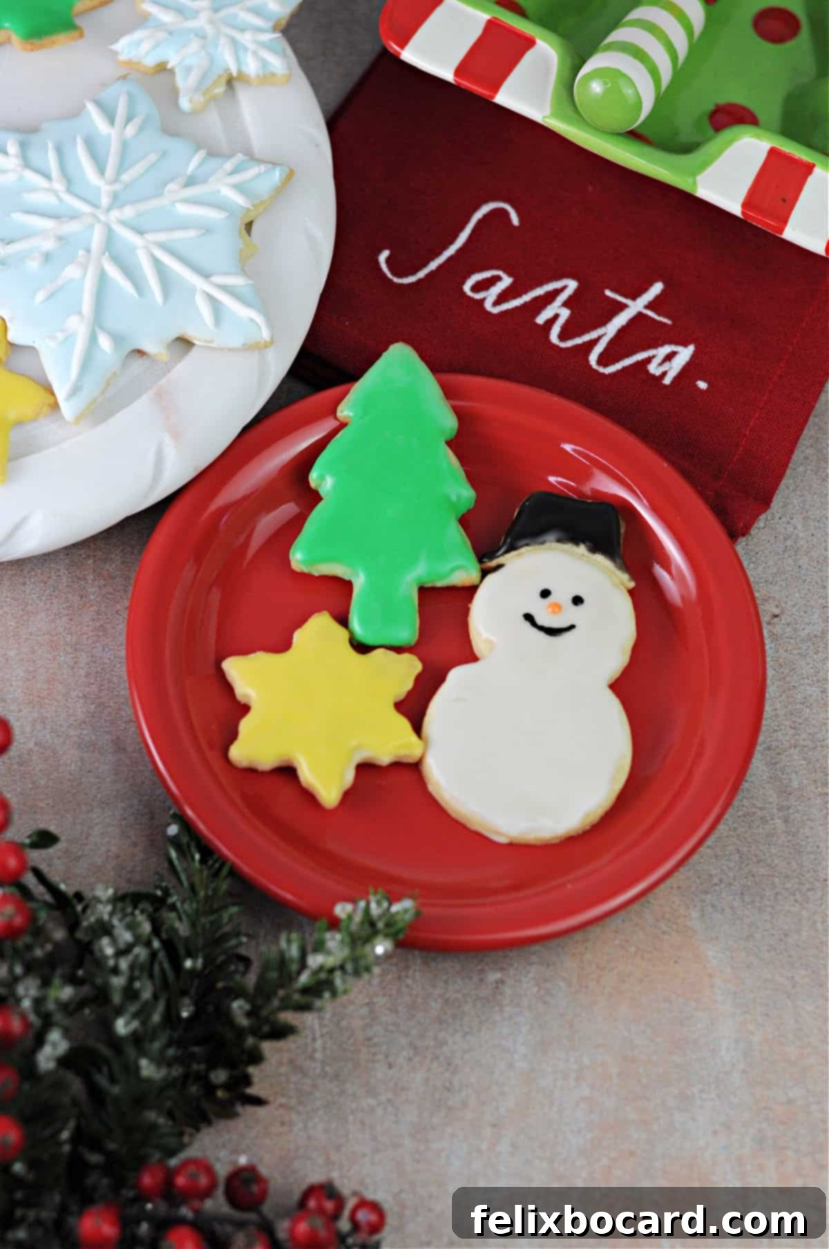 A vibrant red plate filled with beautifully decorated cut-out sugar cookies, showcasing holiday spirit.
