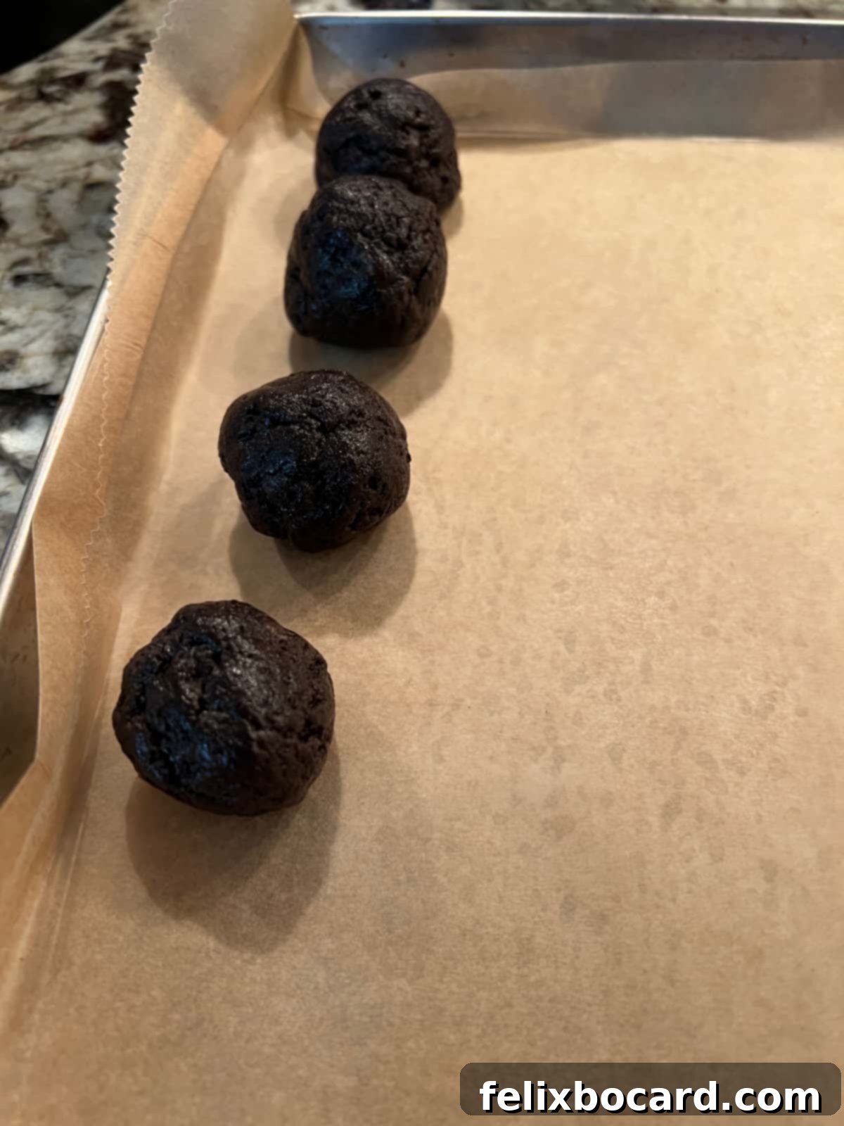 Snowman Oreo Truffles 5 balls placed on parchment lined sheet as they are being formed.