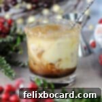 Yuletide White Russian 7 A close-up of an Eggnog White Russian being stirred, showcasing its creamy texture.