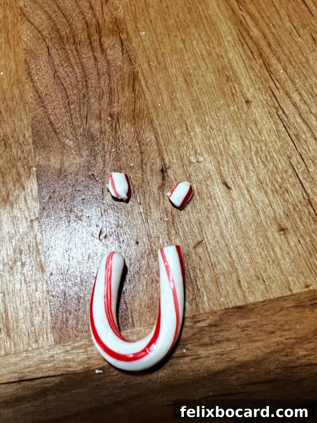 Minty Morning Flapjacks 8 Small, broken pieces of a mini candy cane arranged on a flat surface, attempting to form a tiny, narrow smiley face.