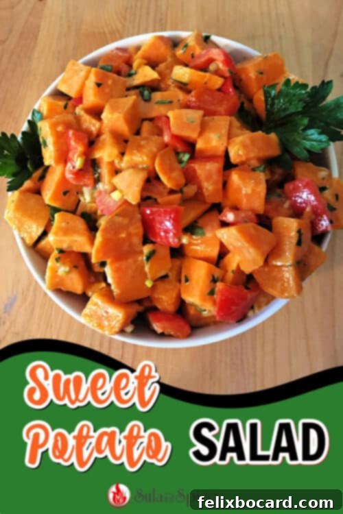 Close-up of sweet potato salad with fresh herbs and a wooden serving spoon.