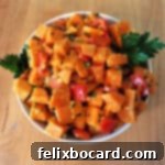 Sweet potato salad in a white serving bowl, garnished.