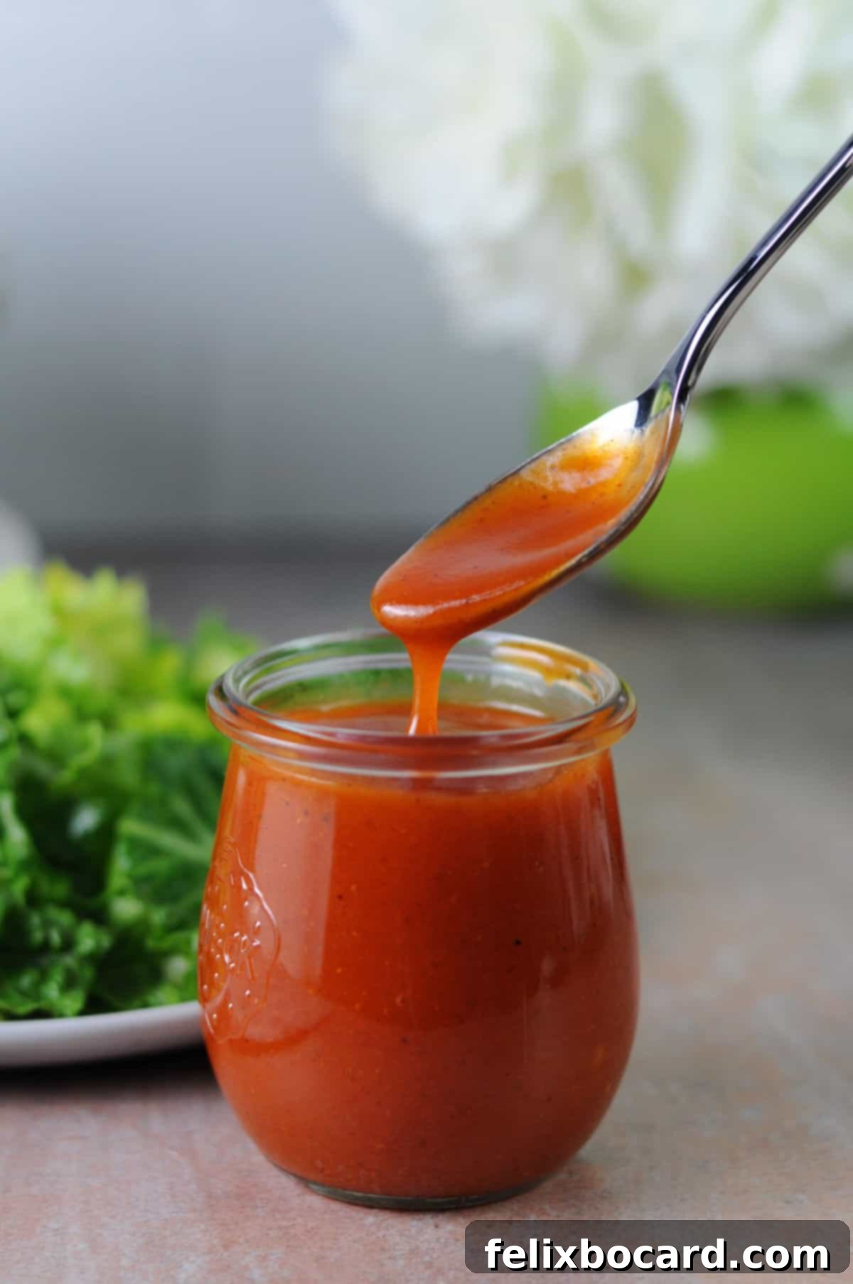 Whip Up Zesty Homemade Catalina Dressing 6 a spoon pouring salad dressing into a small jar.