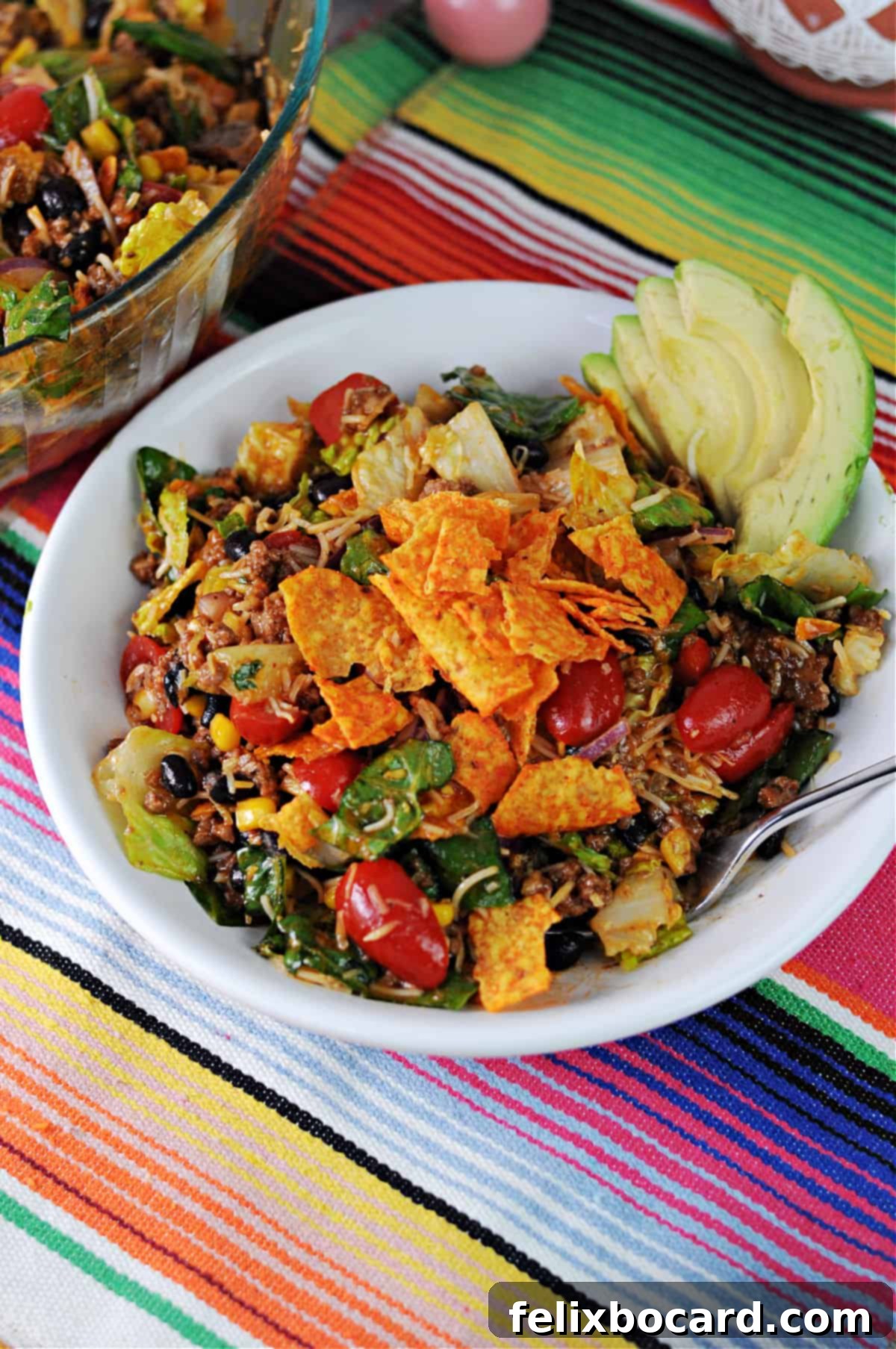 Large meal-sized bowl of vibrant Dorito taco salad topped generously with crunchy Nacho Cheese Doritos.