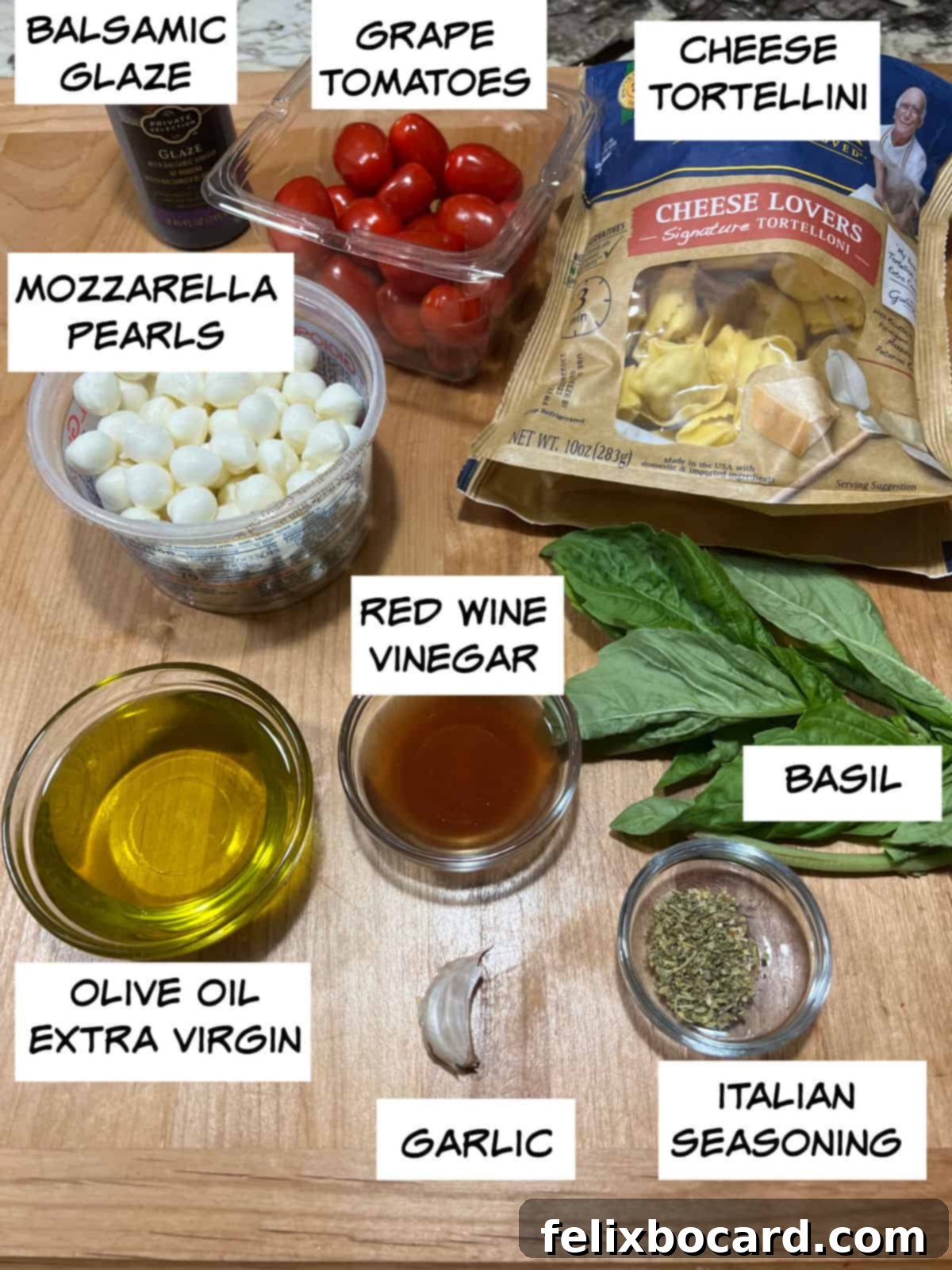 Vibrant Caprese Tortellini Salad 3 A visual guide to Caprese Tortellini Salad ingredients: balsamic glaze, vibrant grape tomatoes, cheese tortellini, fresh mozzarella, fragrant basil, red wine vinegar, olive oil, garlic, and Italian seasoning.