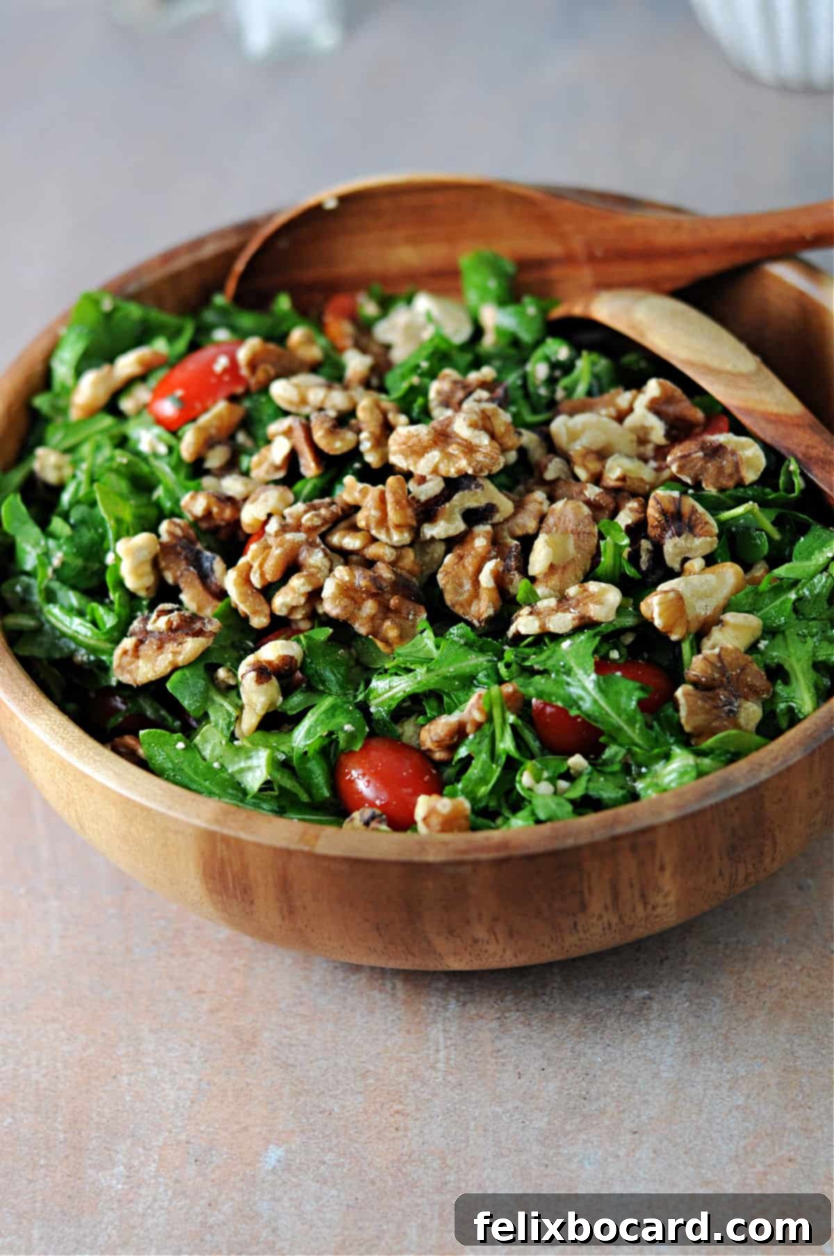 Arugula Feta Tomato Salad, freshly tossed with walnuts, ready to be served.