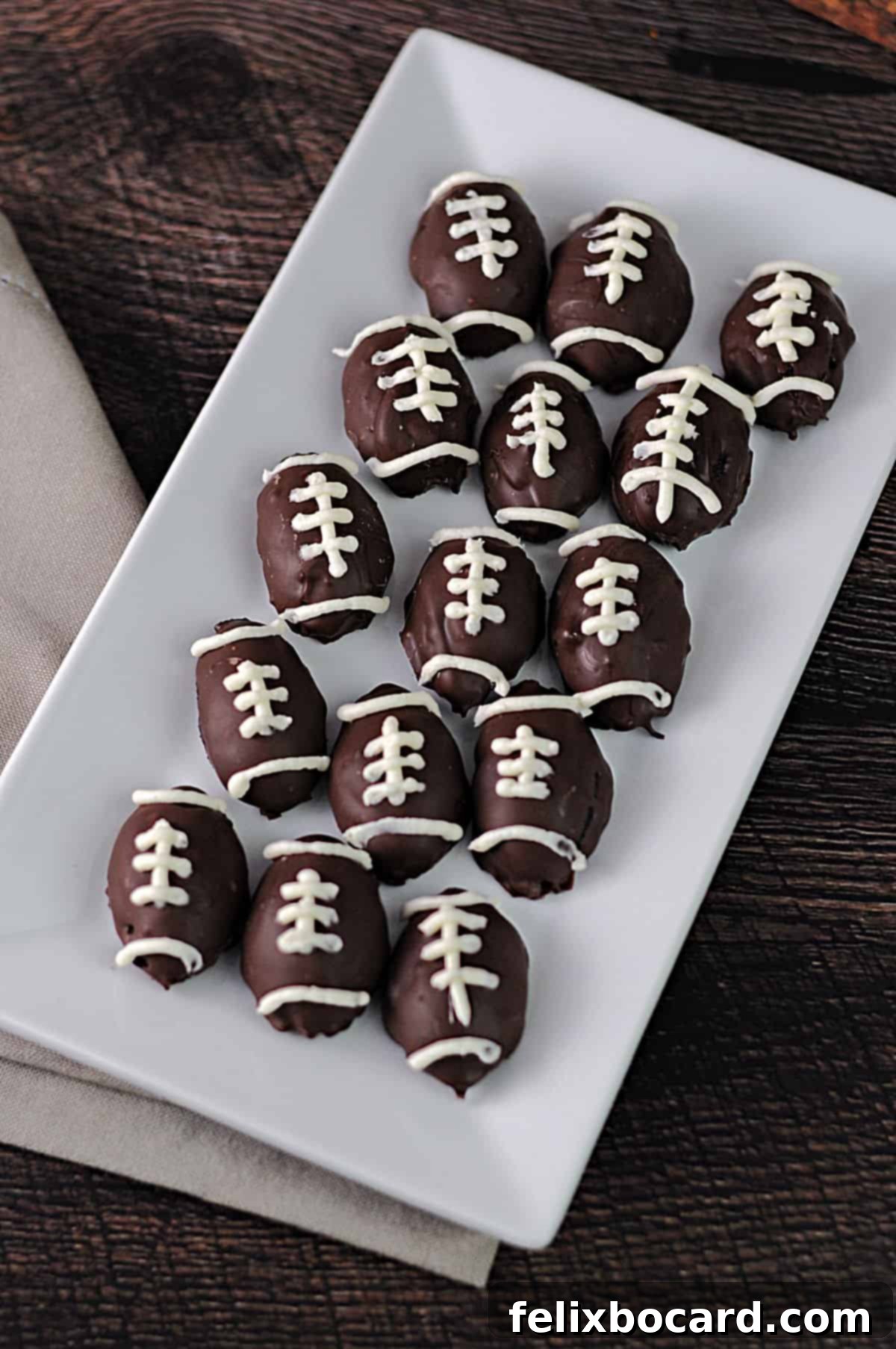 Serving tray of football shaped Oreo truffles, garnished with white laces and presented beautifully for a game day party.