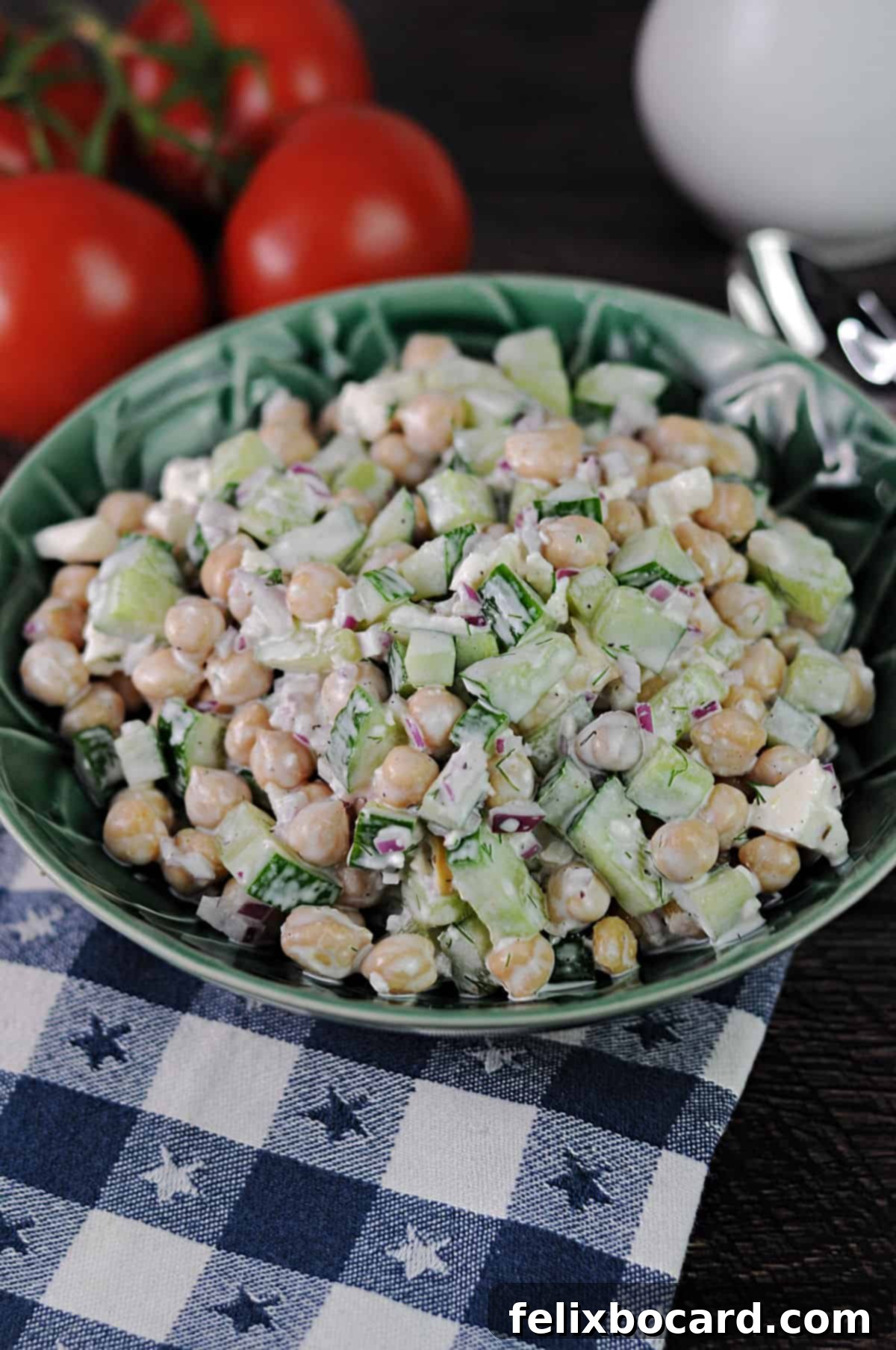 Vibrant cucumber chickpea salad in a serving bowl, garnished with fresh dill and feta.