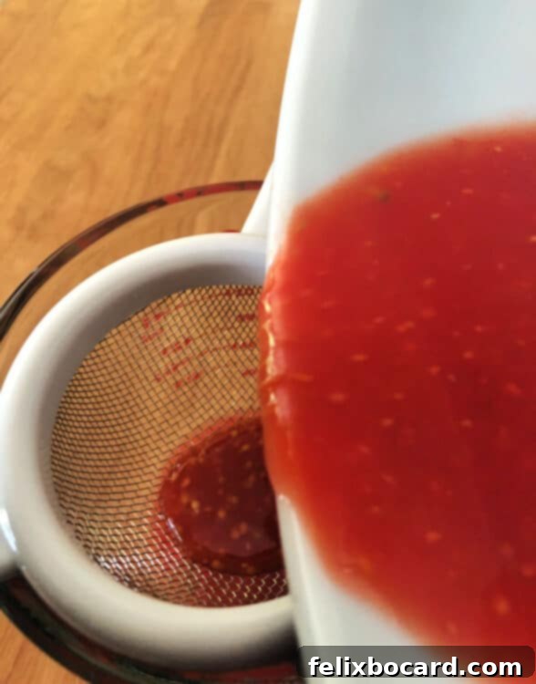 tomato juice pouring througha sieve to strain out the seeds