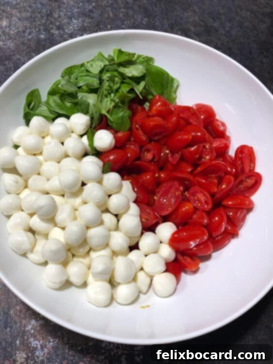 tomatoes, mozzarella pearls and basil in a bowl