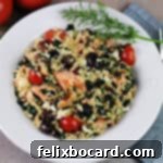 A beautiful bowl of Salmon Orzo Salad, garnished with a sprig of fresh dill, ready to be enjoyed.