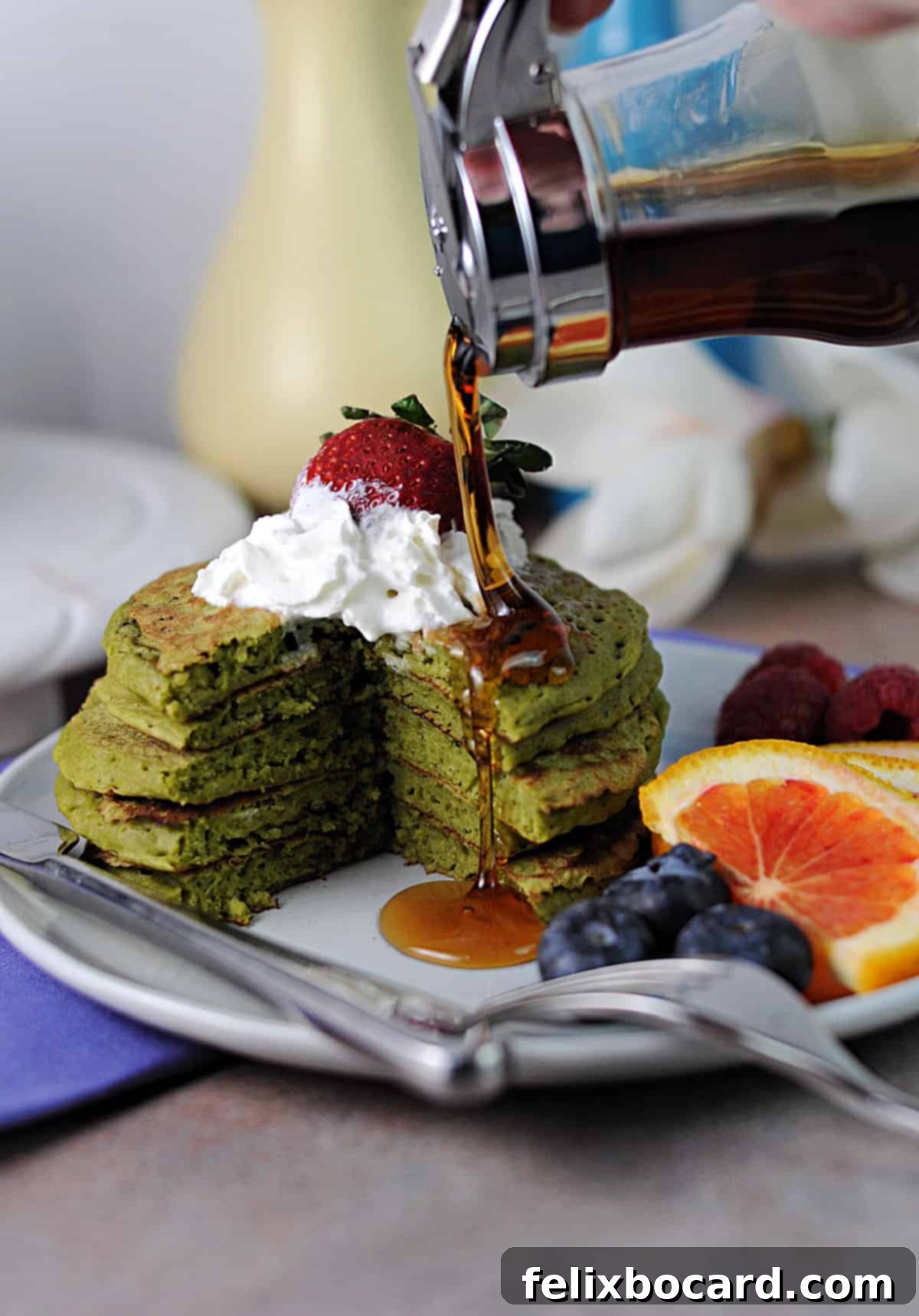 Fluffy Matcha Pancakes 2 Syrup pouring generously over a beautiful stack of vibrant green matcha pancakes, ready to be enjoyed.