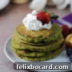Fluffy Matcha Pancakes 8 A delightful stack of vibrant green matcha pancakes, elegantly garnished with a swirl of whipped cream and a fresh strawberry on top.
