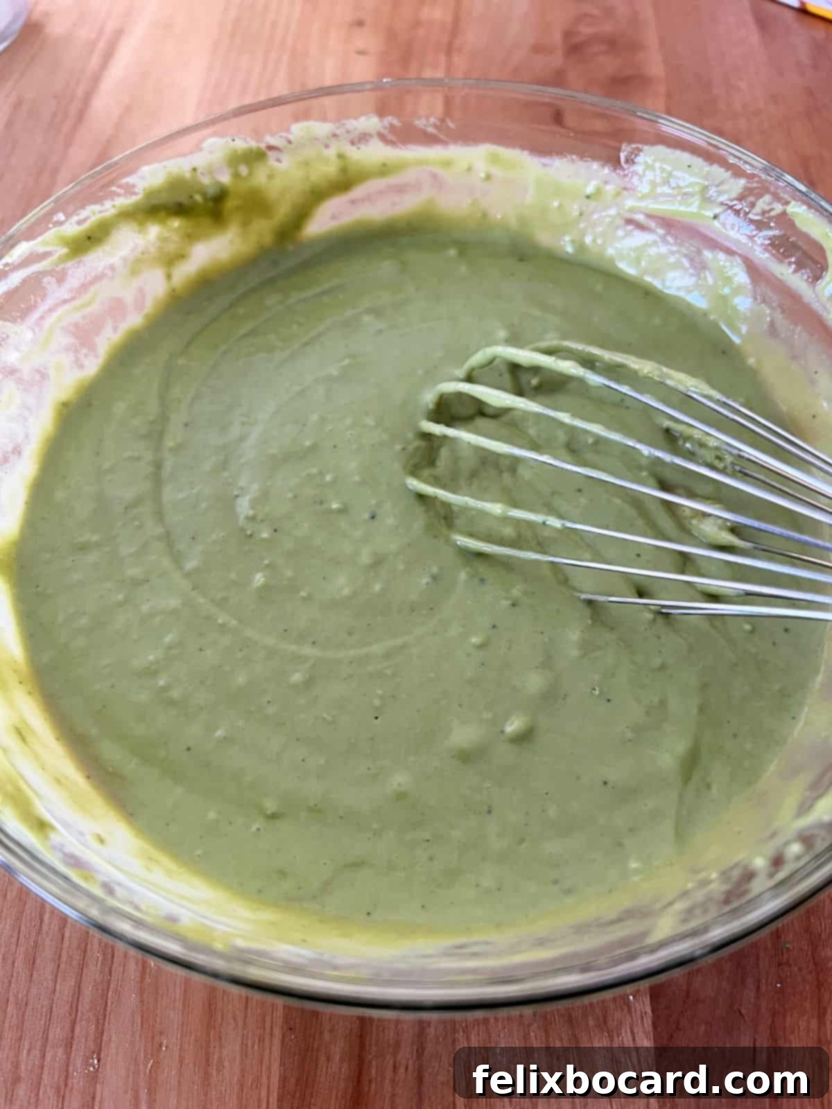 Fluffy Matcha Pancakes 5 Vibrant green matcha pancake batter, perfectly mixed and ready to be cooked, sitting in a bowl.