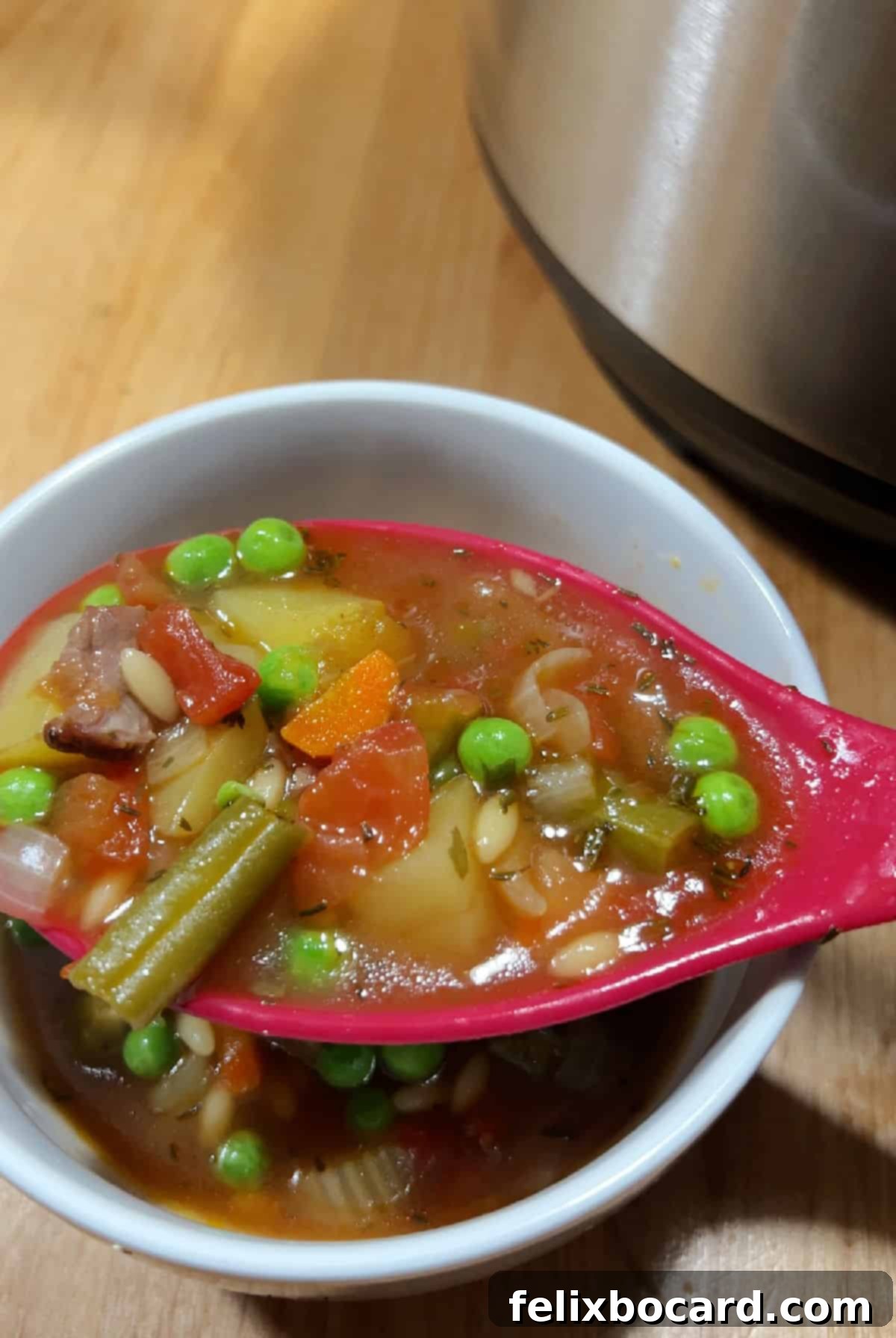 Effortless Instant Pot Beef & Vegetable Soup 8 A soup ladle spooning a generous portion of finished Instant Pot vegetable beef soup into a ceramic bowl.