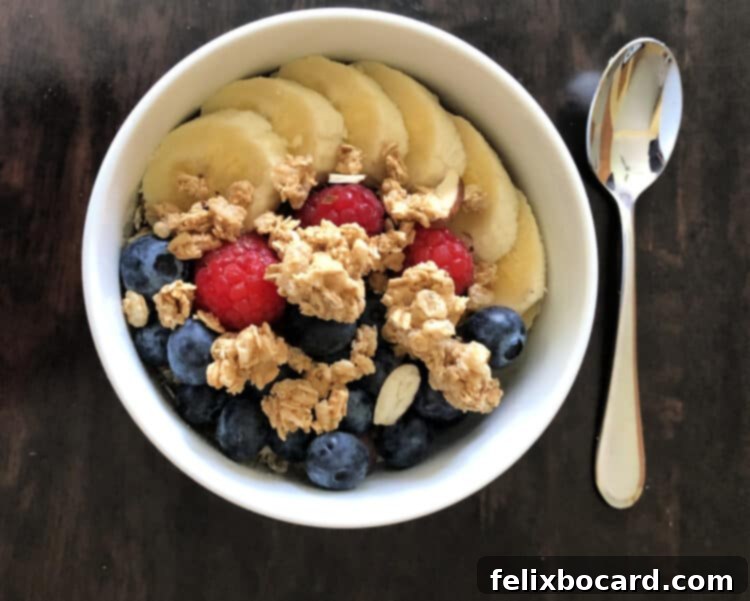 Creamy Almond Milk Stovetop Oats 3 A close-up of a bowl of oatmeal topped with fresh blueberries and raspberries, showcasing vibrant colors.