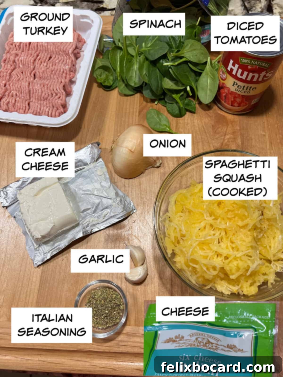 A colorful array of fresh ingredients laid out: lean ground turkey, vibrant spinach, juicy diced tomatoes, creamy cream cheese, aromatic onion, perfectly cooked spaghetti squash, pungent garlic, fragrant Italian seasoning, and a generous heap of shredded cheese.