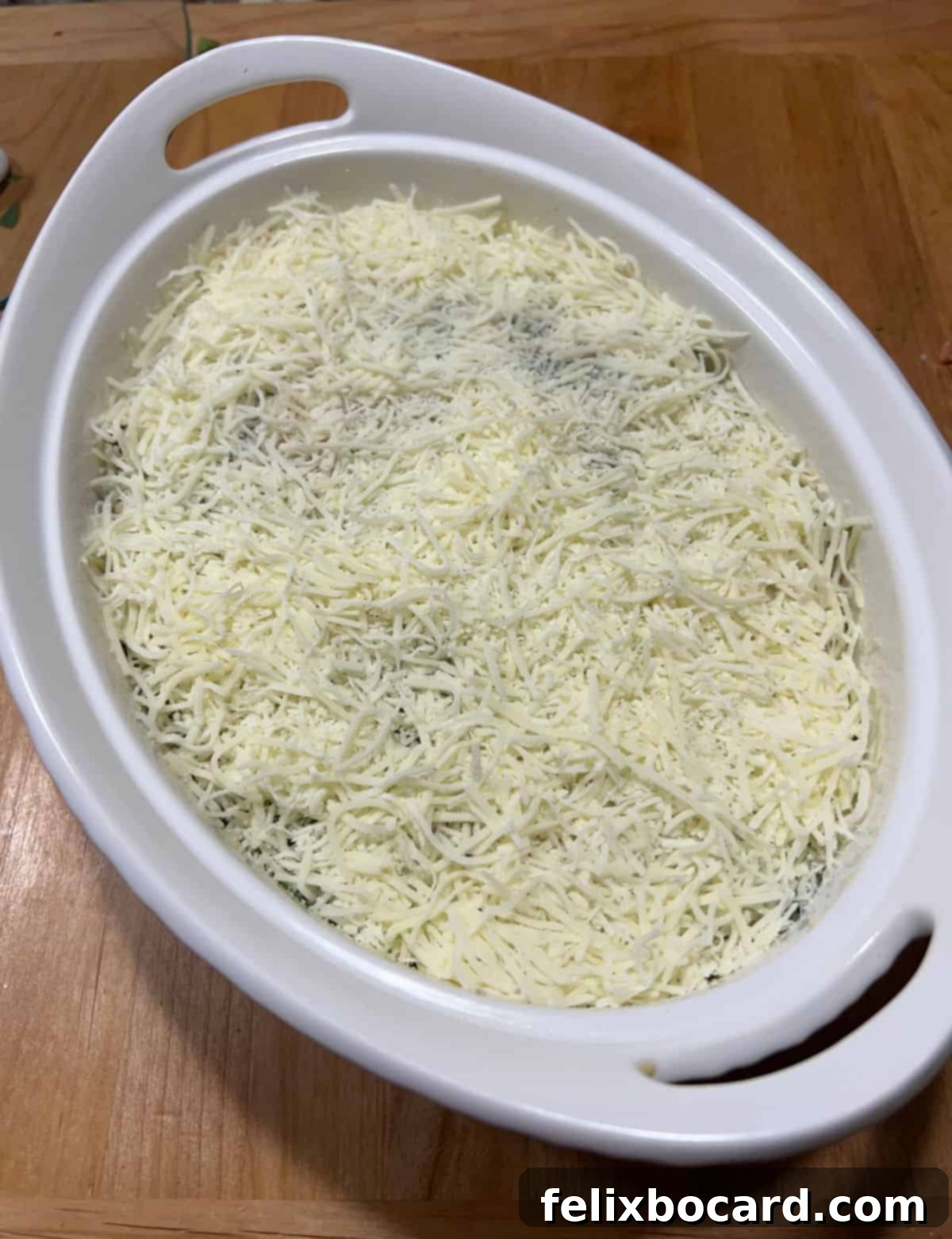 The spaghetti squash and turkey mixture nestled in a casserole dish, lavishly topped with shredded cheese, poised for baking.