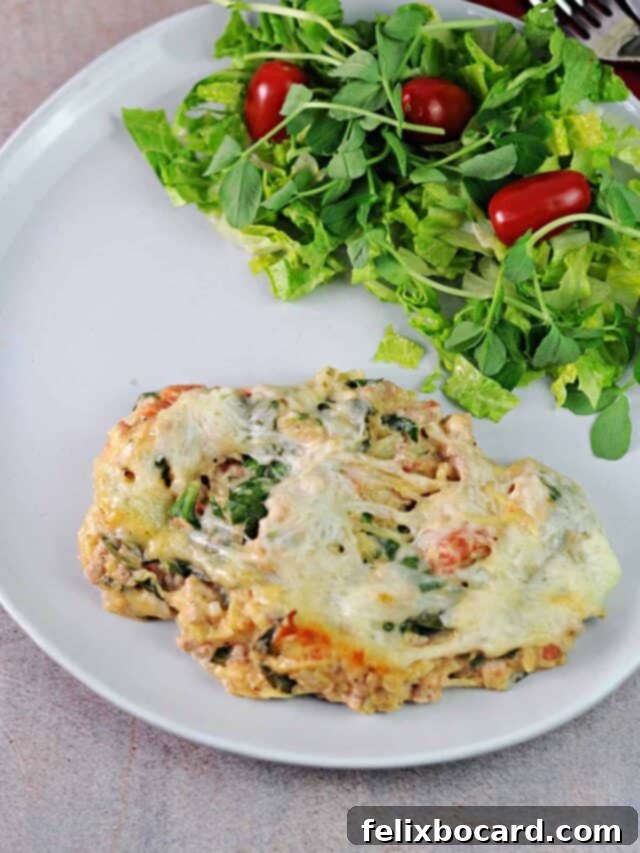 A satisfying serving of spaghetti squash and turkey casserole presented on a plate, accompanied by a crisp, fresh green salad, highlighting a complete and balanced meal.