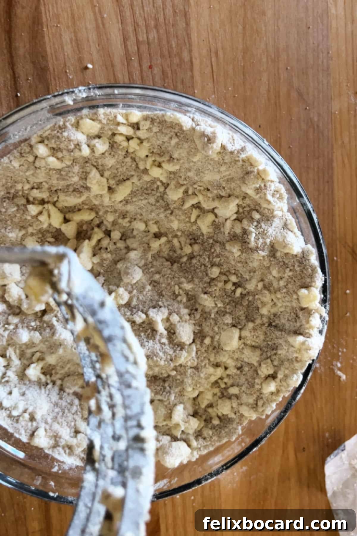 Close-up of streusel topping in a mixing bowl, showing coarse crumbs.