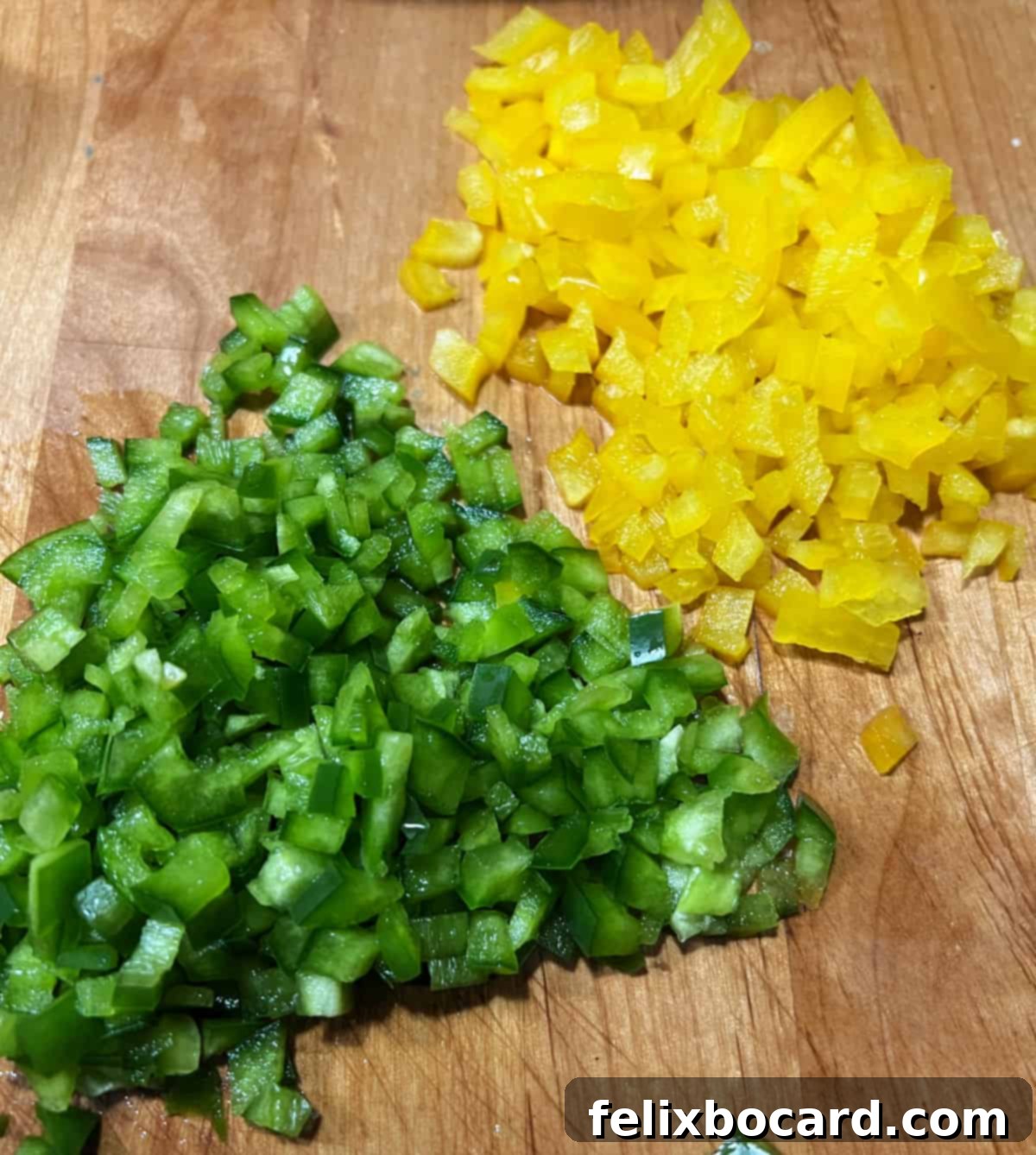 Finely chopped green bell pepper and yellow bell pepper, prepared and ready to be used for creating the Green Bay Packers logo on the taco dip.