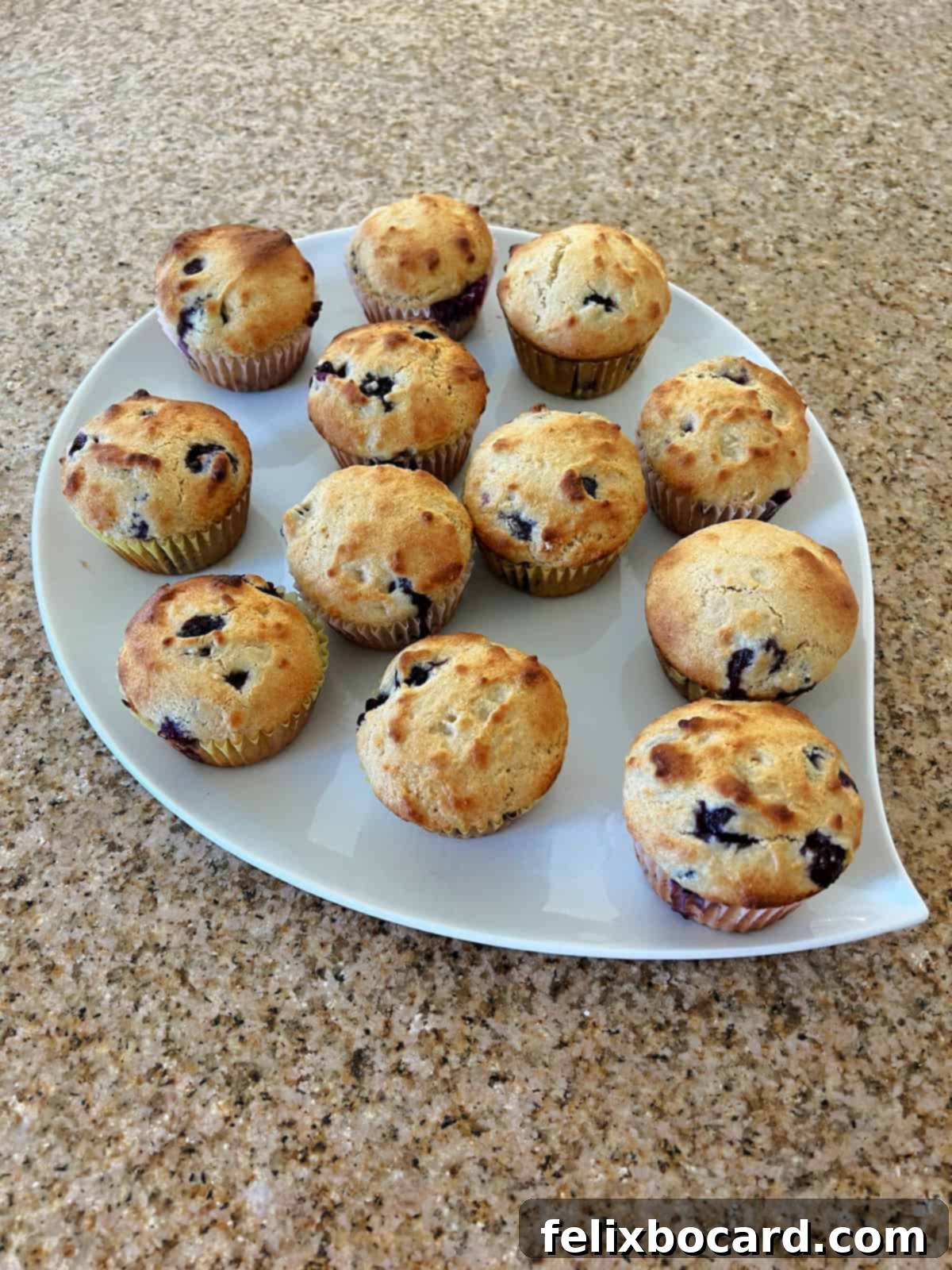 A beautiful wooden tray laden with freshly baked blueberry muffins made from pancake mix, showcasing their golden tops and plump blueberries.