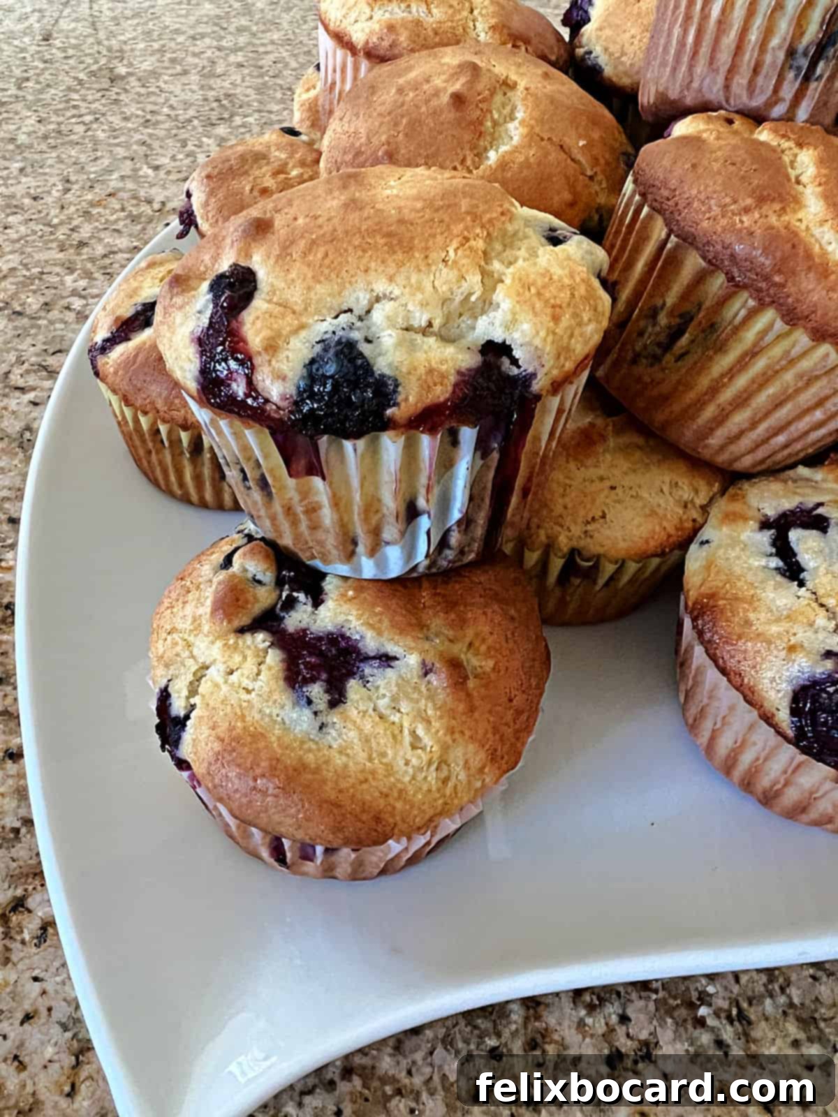 A generous tray piled high with golden, fluffy blueberry muffins made with pancake mix, showcasing their inviting texture.
