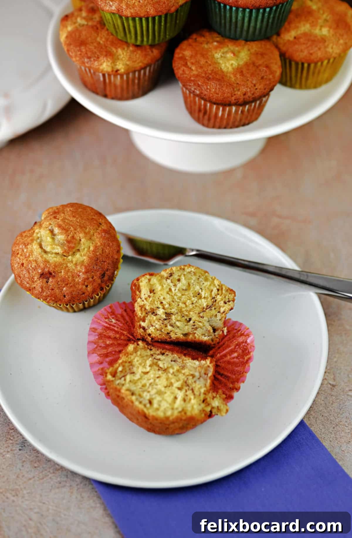 A perfectly cut-open banana bread muffin, revealing its moist, tender interior with visible banana pieces, resting on a serving plate, ready to be enjoyed as a delightful snack or breakfast.