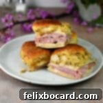 Hawaiian Ham and Cheese Sliders 9 Three ham and cheese sliders from the air fryer on a small plate, ready to eat.