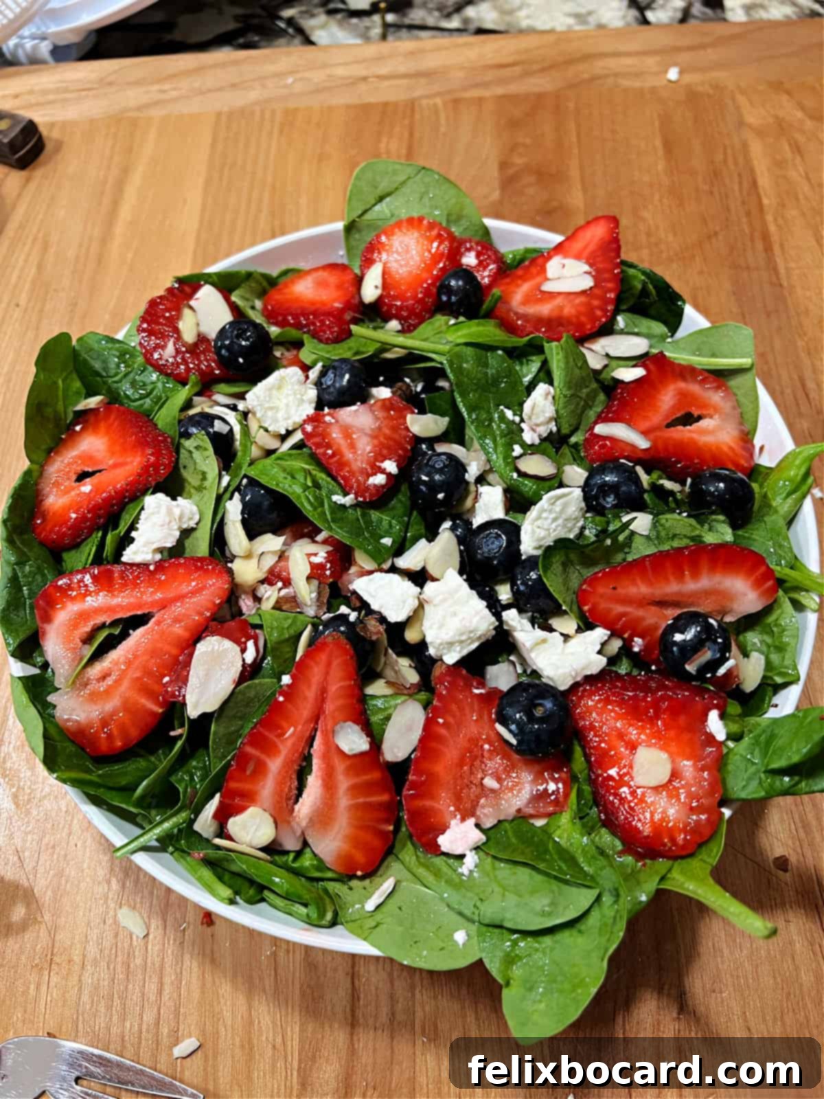 Blueberry strawberry and spinach salad tossed in the bowl.