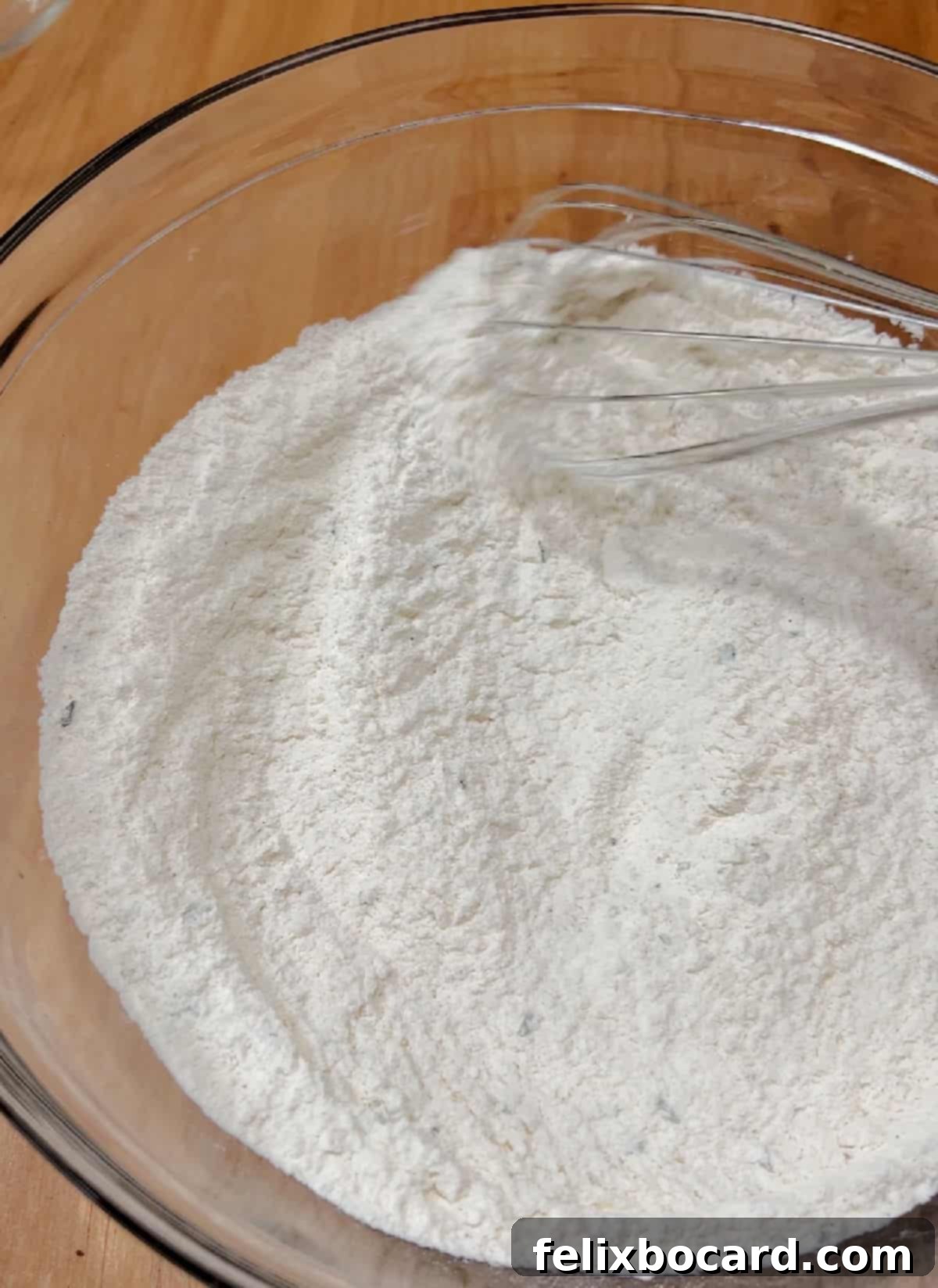 Savory Sun Dried Tomato Quick Bread 4 Dry ingredients for sun-dried tomato bread being whisked together in a large mixing bowl.