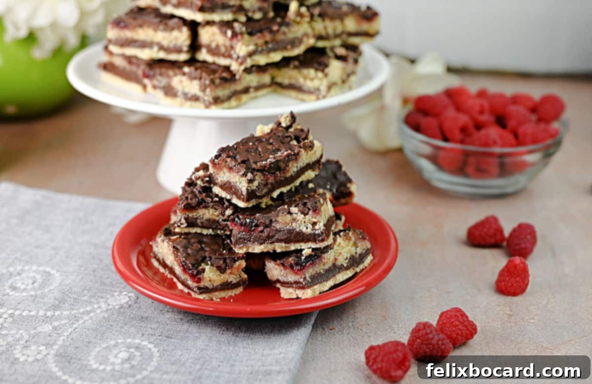 Plate stacked high with chocolate raspberry bars, showcasing their delicious layers and crumbly texture.
