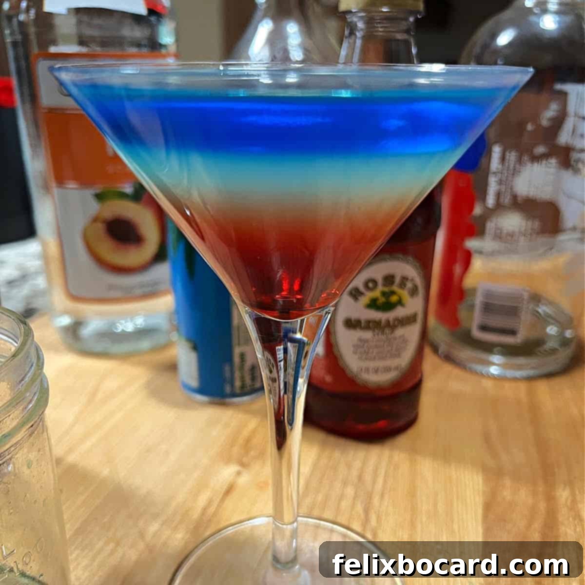 Rainbow martini showing bright colored layers, presented beautifully.