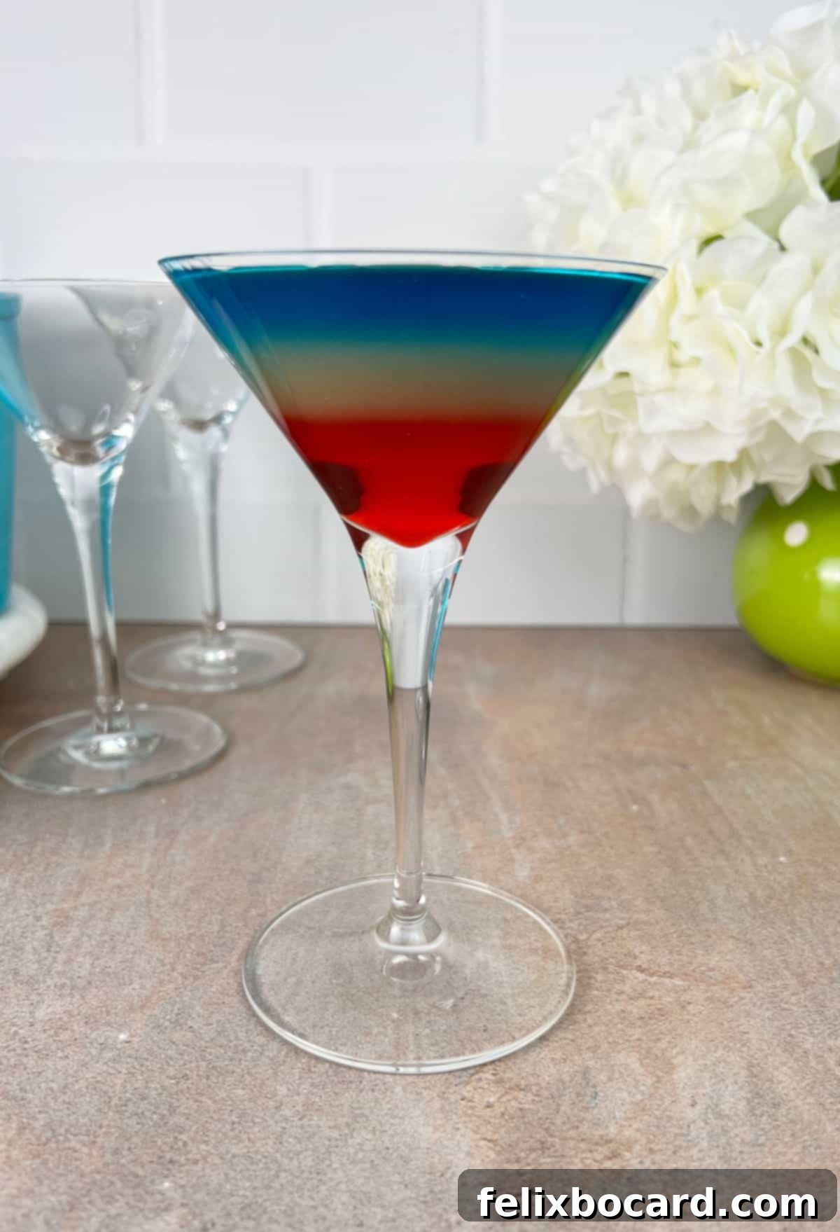 Completed rainbow martini cocktail showing the vibrant colors in distinct layers.