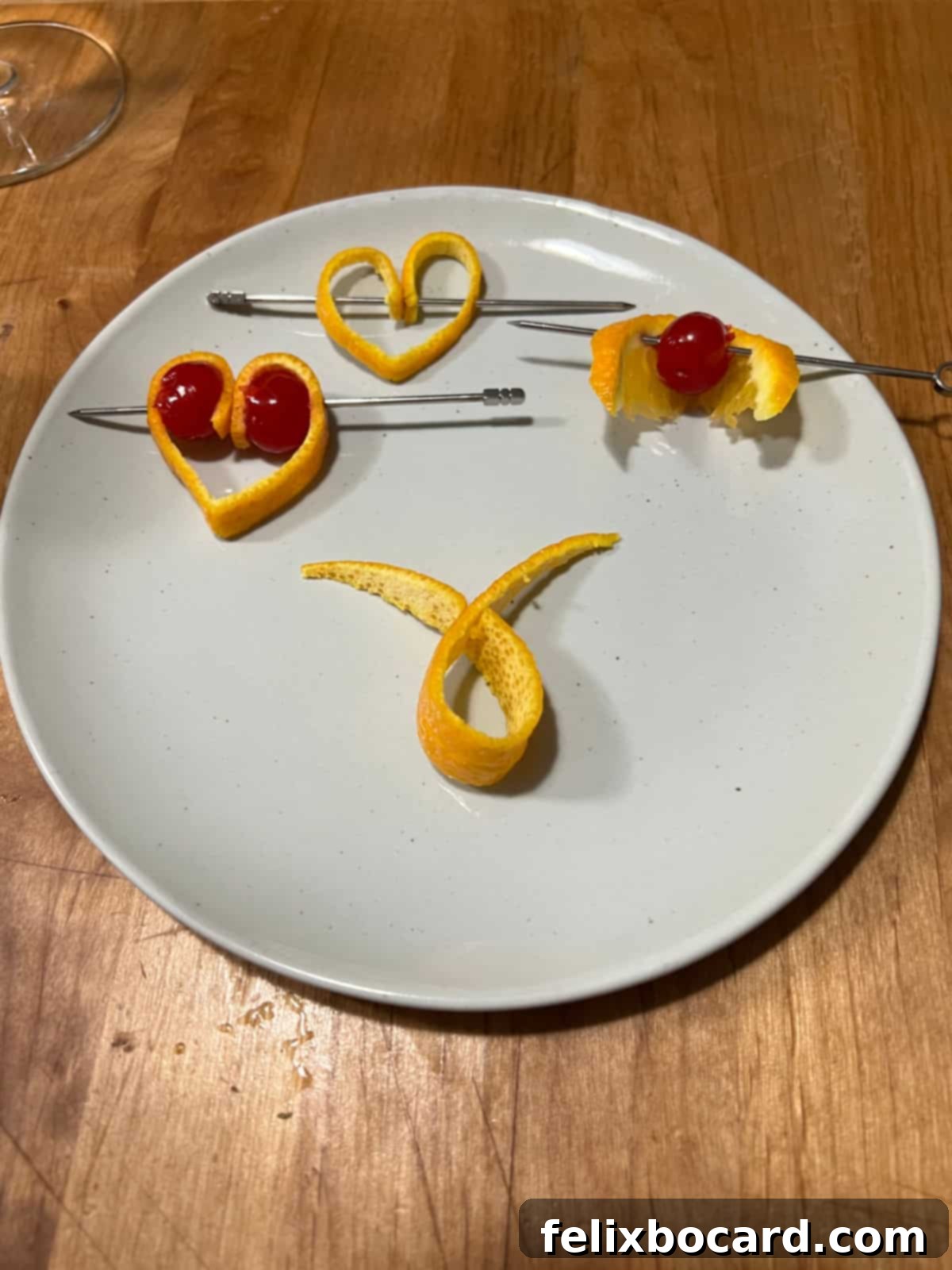 A variety of garnishes made from orange peel and cherries displayed neatly.