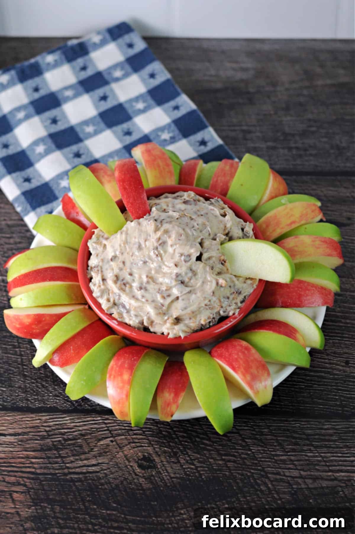 a bowl of heath bar apple dip surrounded by slices of apple.
