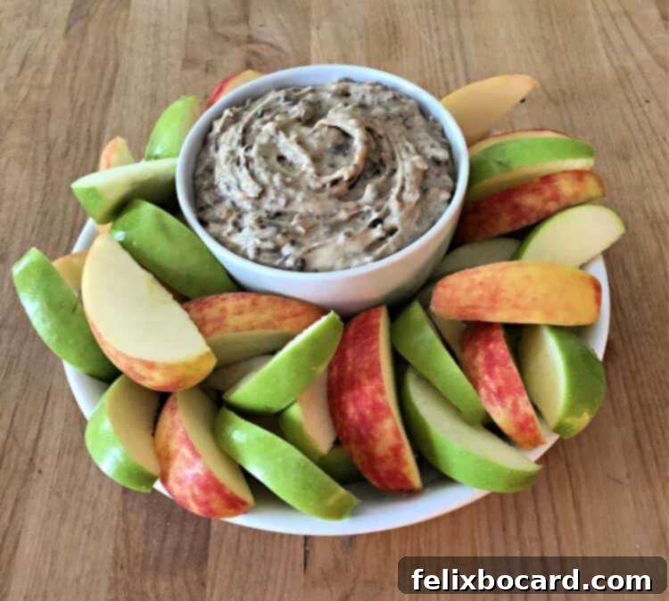 bowl of heath bar dip surrounded by slices of red and green apple