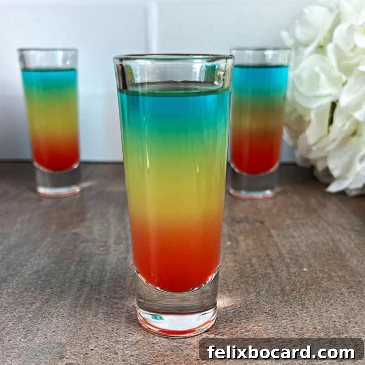 Rainbow shots ready to serve, with distinct blue, yellow, and red layers.
