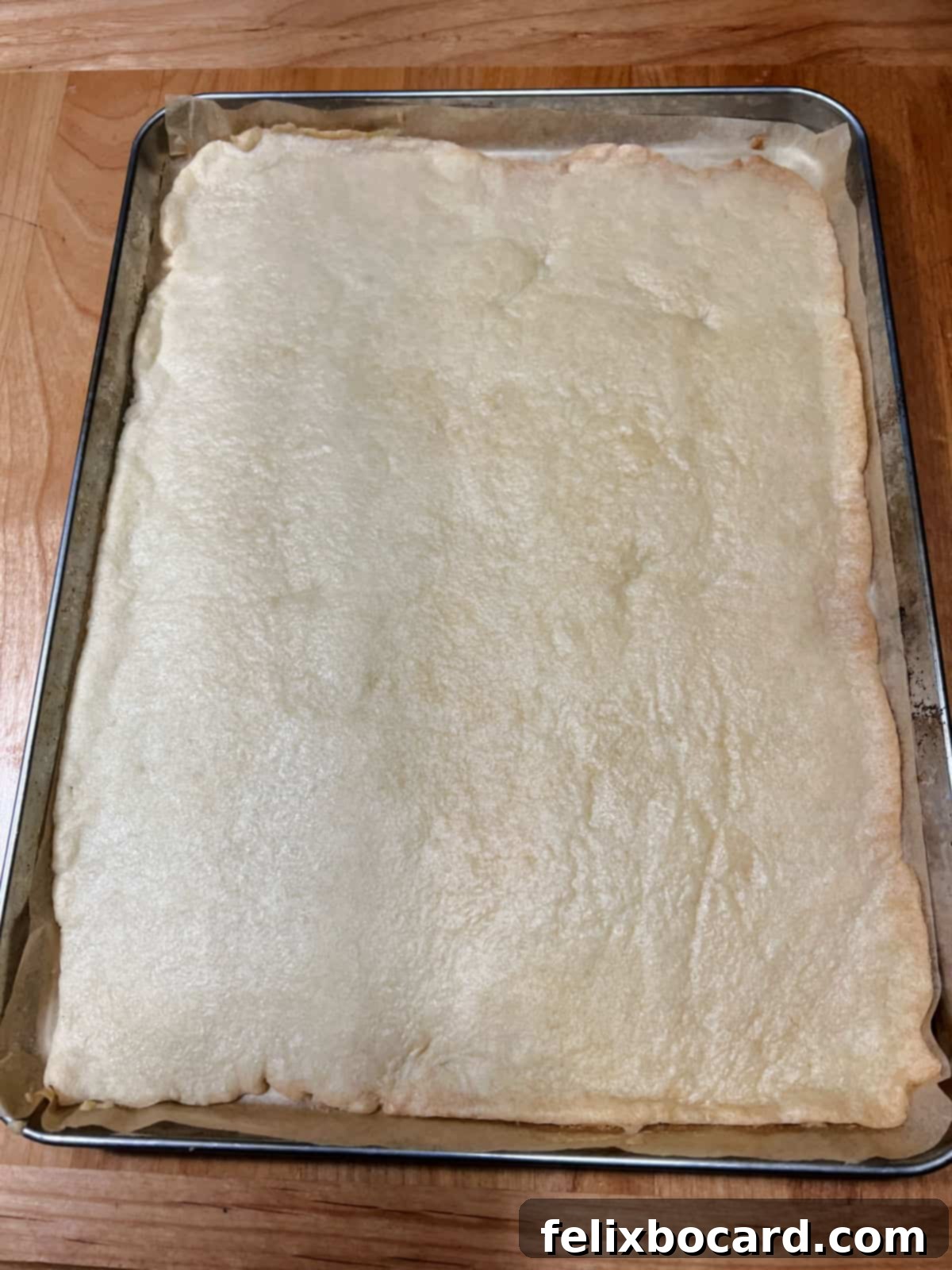 A perfectly baked sugar cookie crust, lightly golden brown and cooled, sitting in a baking pan.