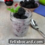 Blackberry Chia Seed pudding in a small jar, garnished with fresh berries and a sprig of mint.