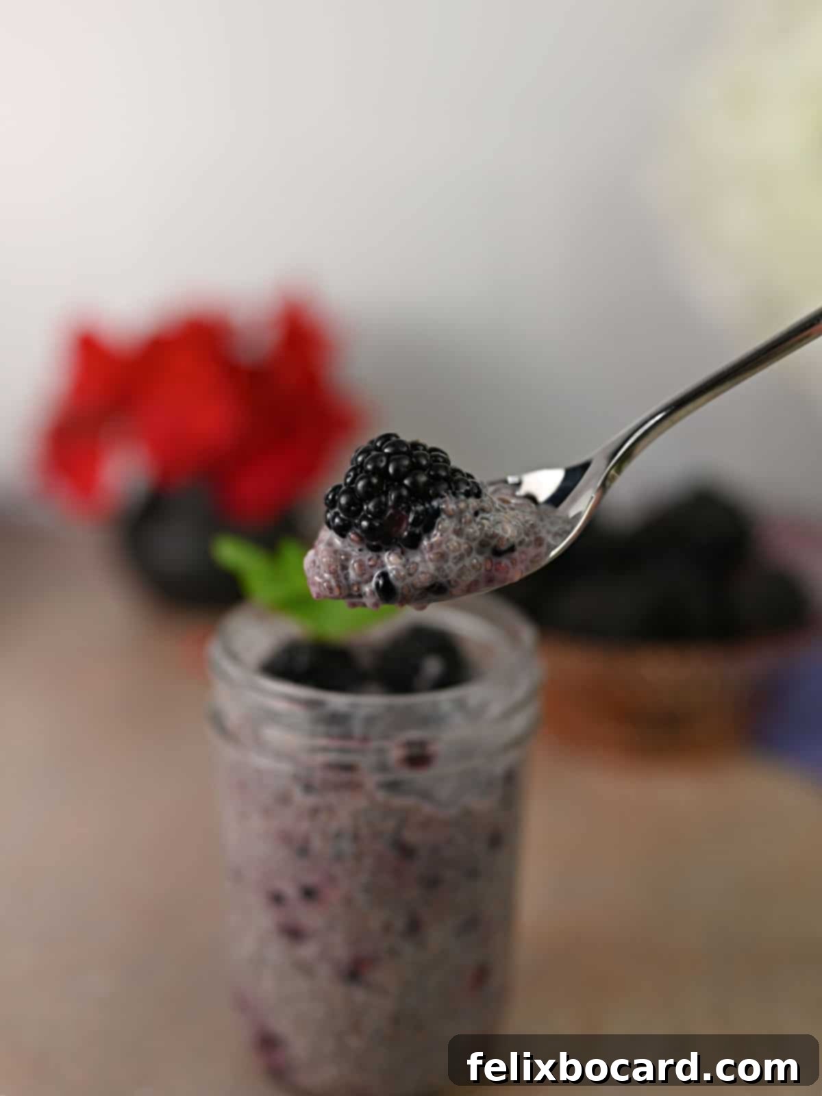 A spoon laden with blackberry chia pudding, showcasing its thick, ready-to-eat consistency.