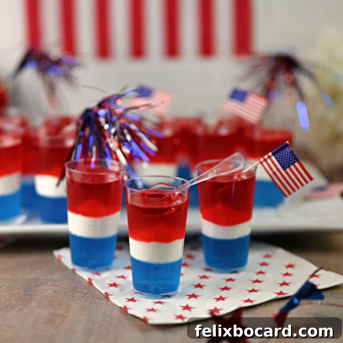Close-up of three Red, White, and Blue Jello shots showing clear layers.