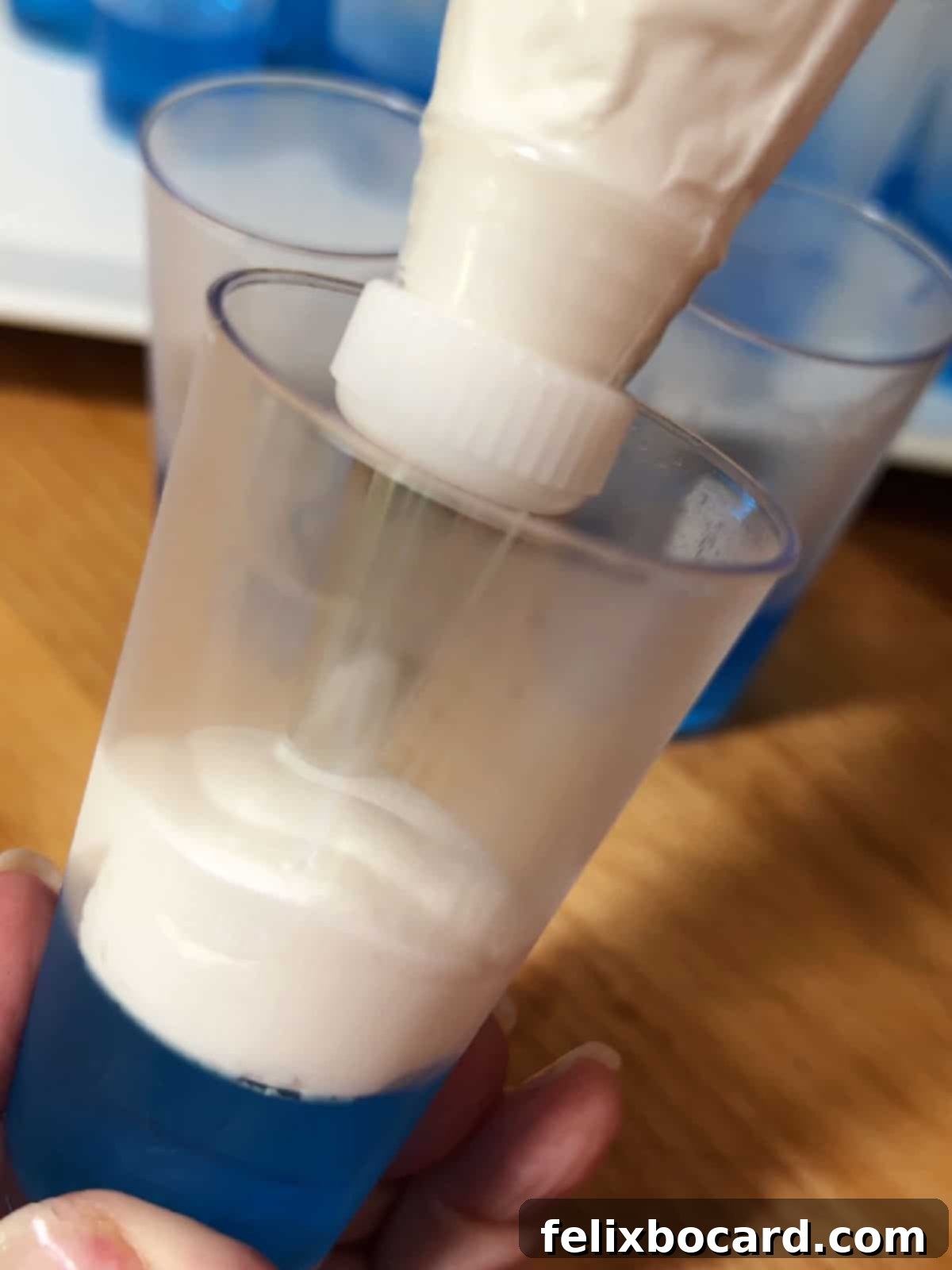 Adding Cool Whip layer to the blue jello using a pastry bag for precision.