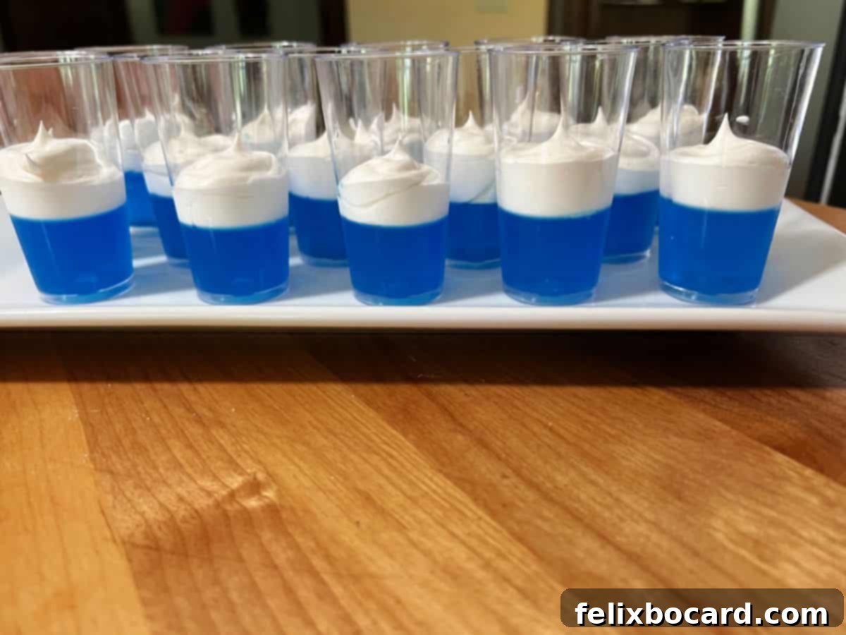 White serving plate displaying shot glasses with the completed blue and white layers.