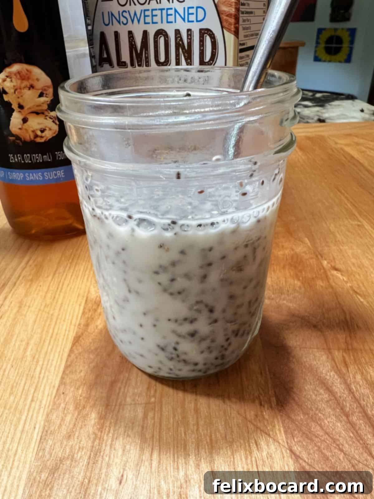 Chia seeds and almond milk stirred thoroughly in a jar, showing an even distribution before adding mango.