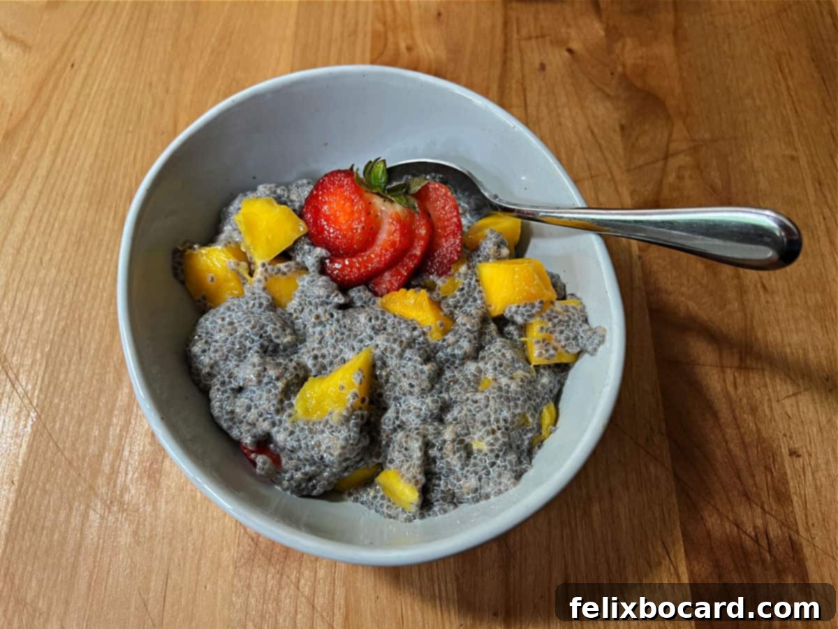 A bowl of creamy mango chia seed pudding, elegantly garnished with a fresh strawberry slice.