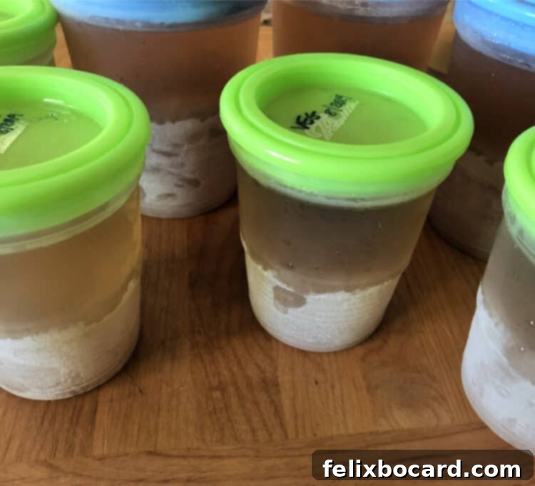 Fully frozen, perfectly filled plastic jars of homemade vegetable broth.