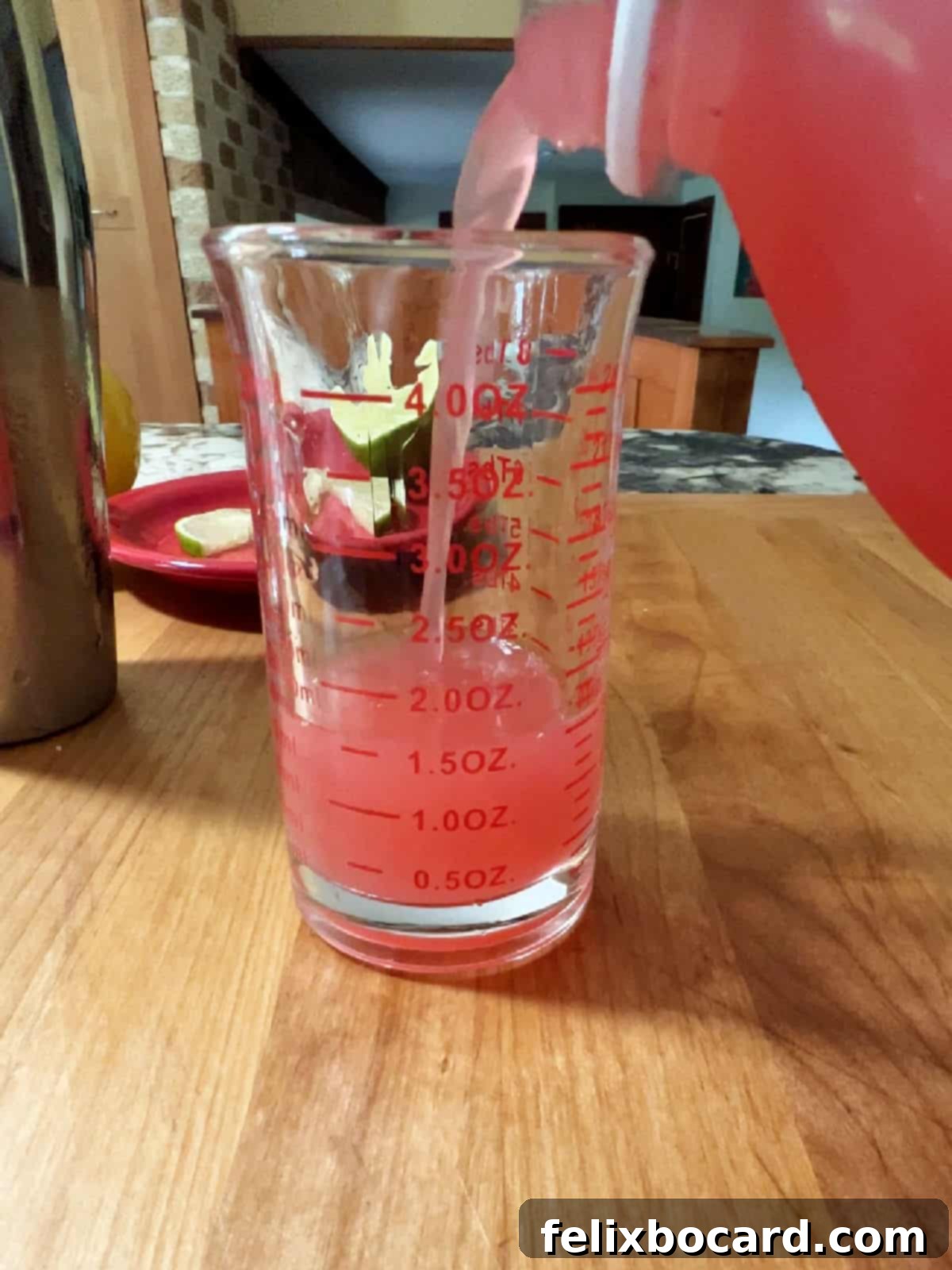 Blushing Grapefruit Margarita 6 Pouring pink grapefruit juice into a measuring glass for a margarita.