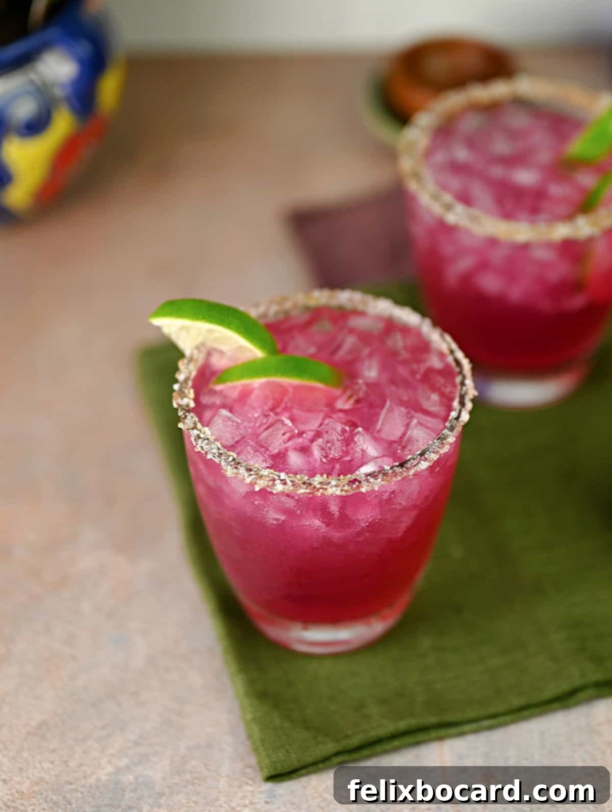 Beautifully prepared prickly pear margaritas garnished with lime, ready for drinking.