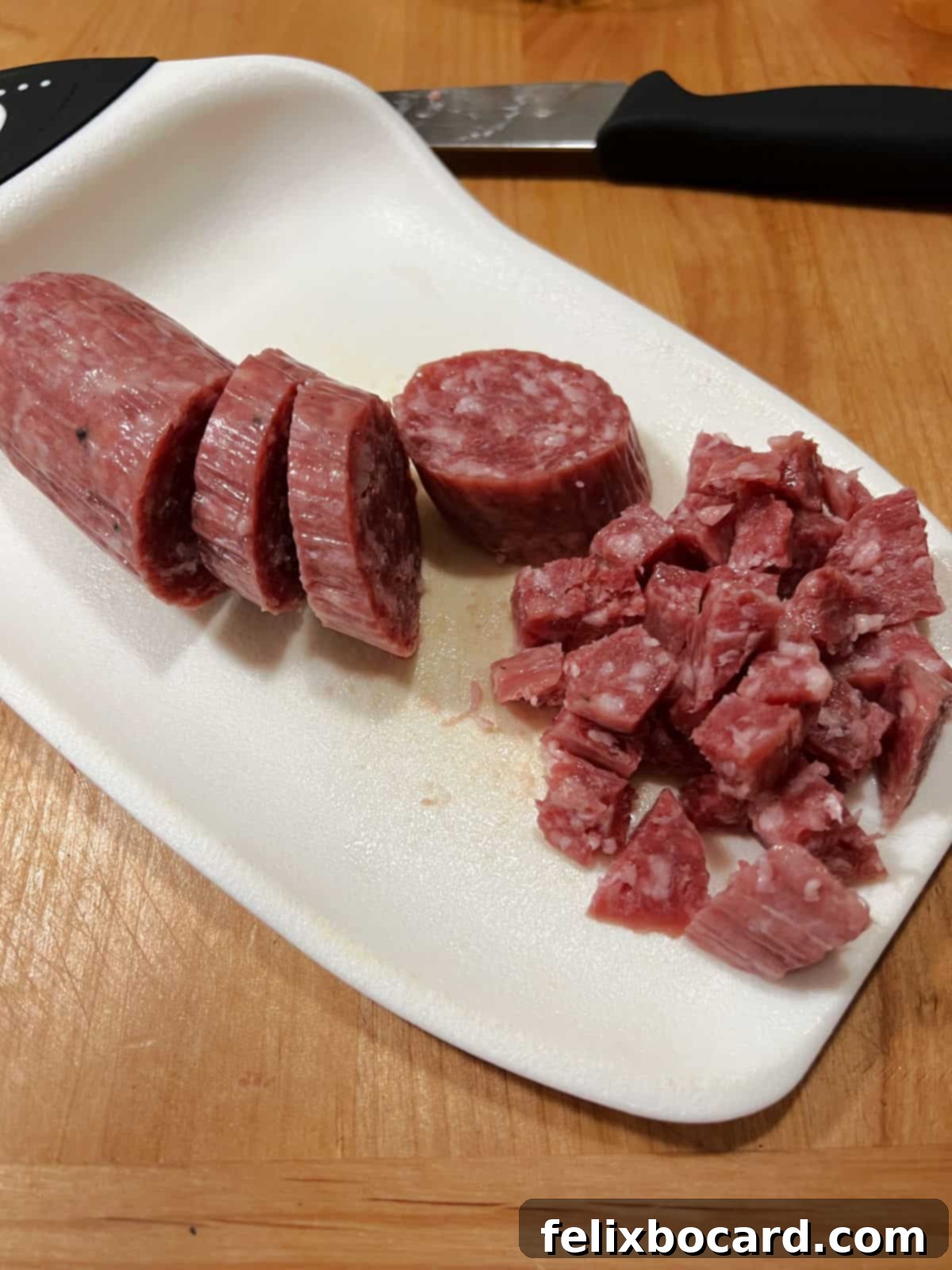 Chopping salami into bite sized chunks.